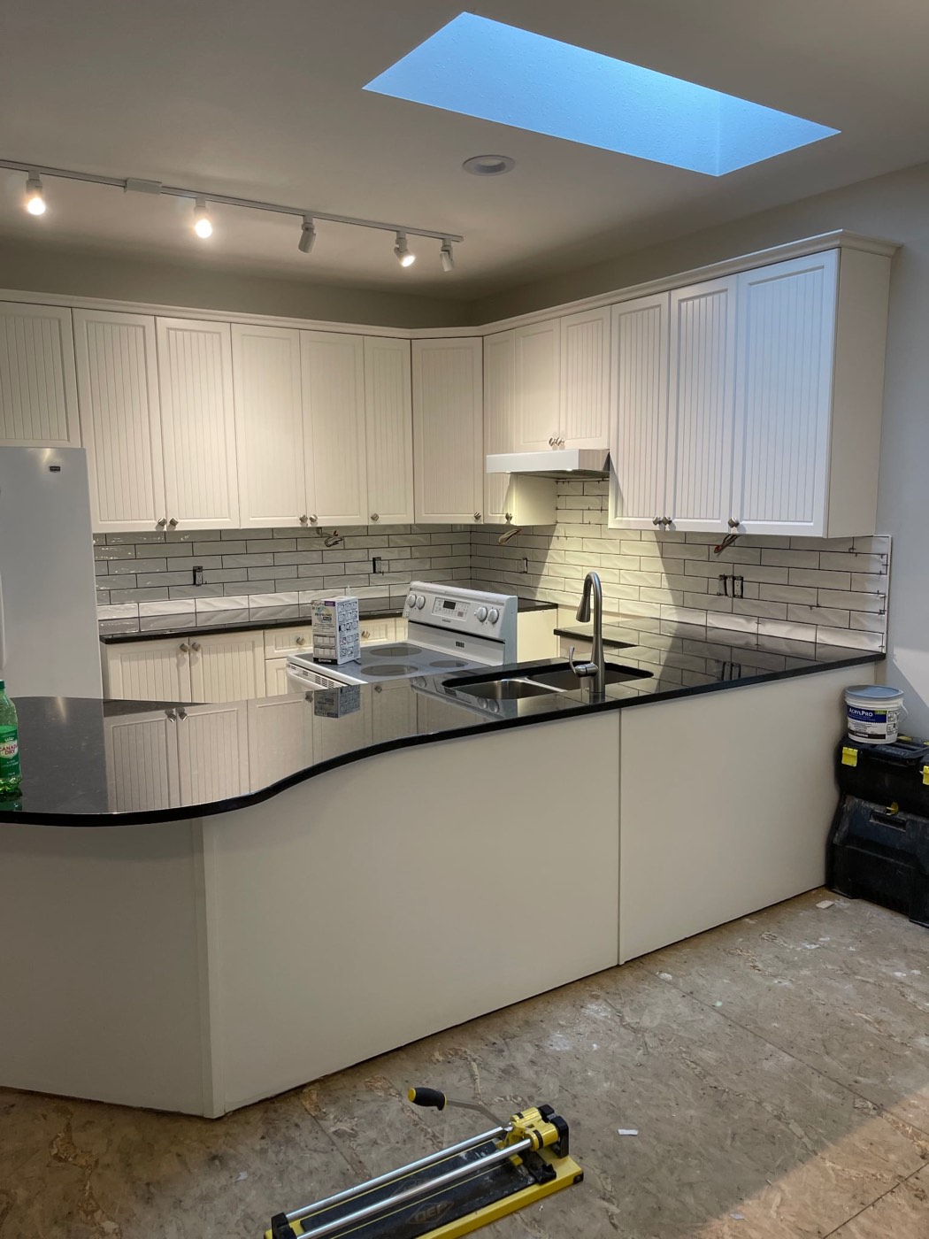 Kitchen backsplash after renovation, white subway tile
